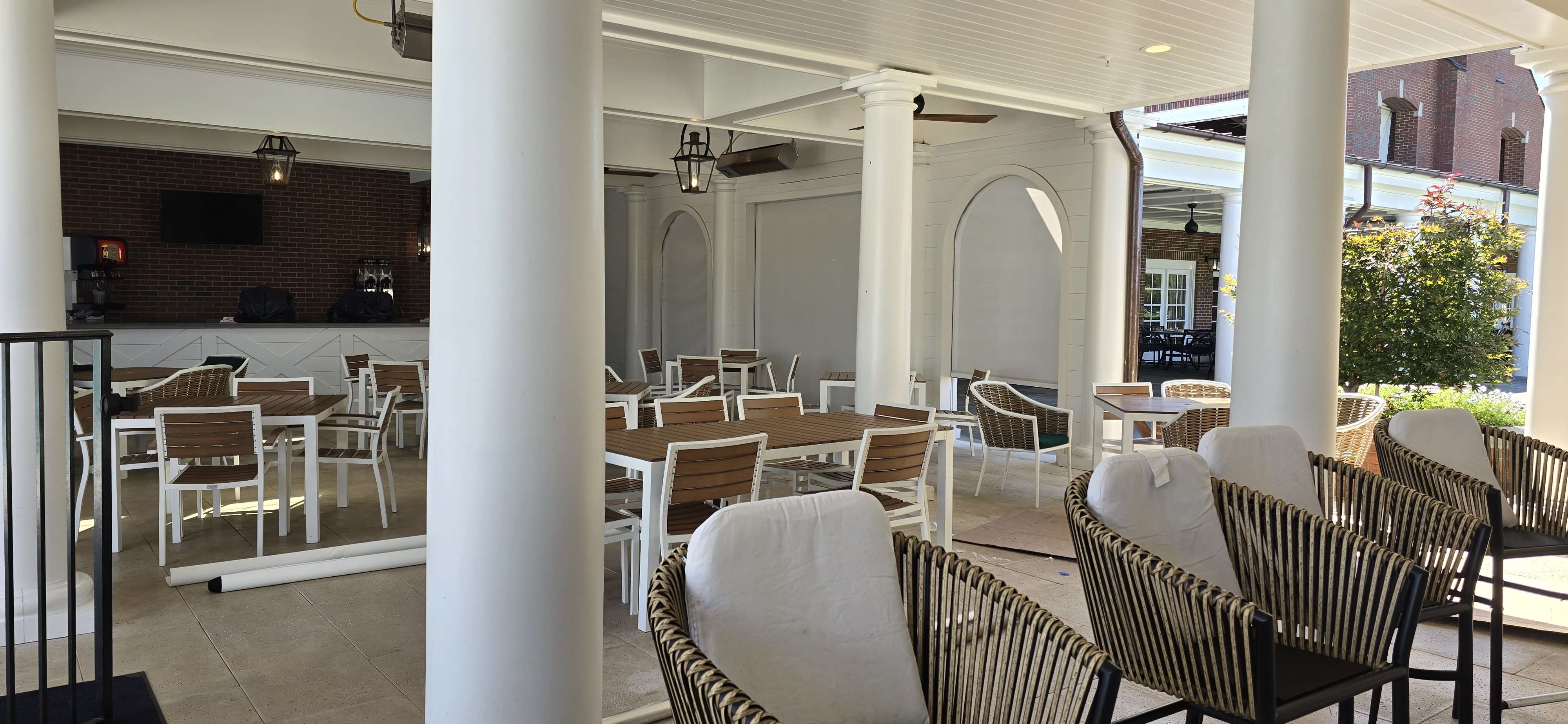 Exterior solar shades on a covered clubhouse patio with white columns and patio dining